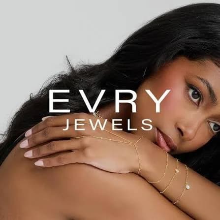 Model wearing Evry Jewels layered gold hand chain and bracelets