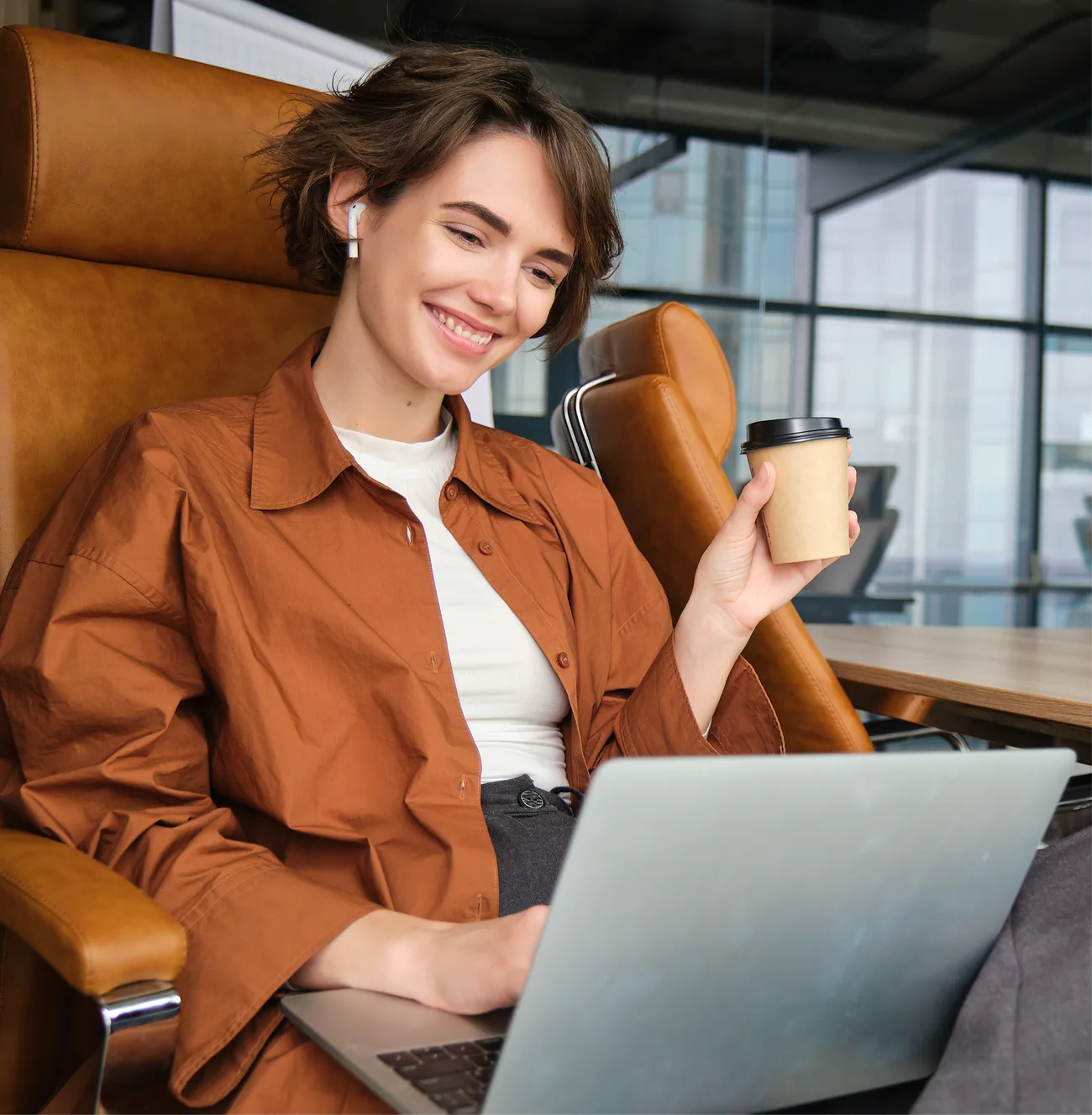 A CX leader smiling while reviewing the benchmark report on a laptop