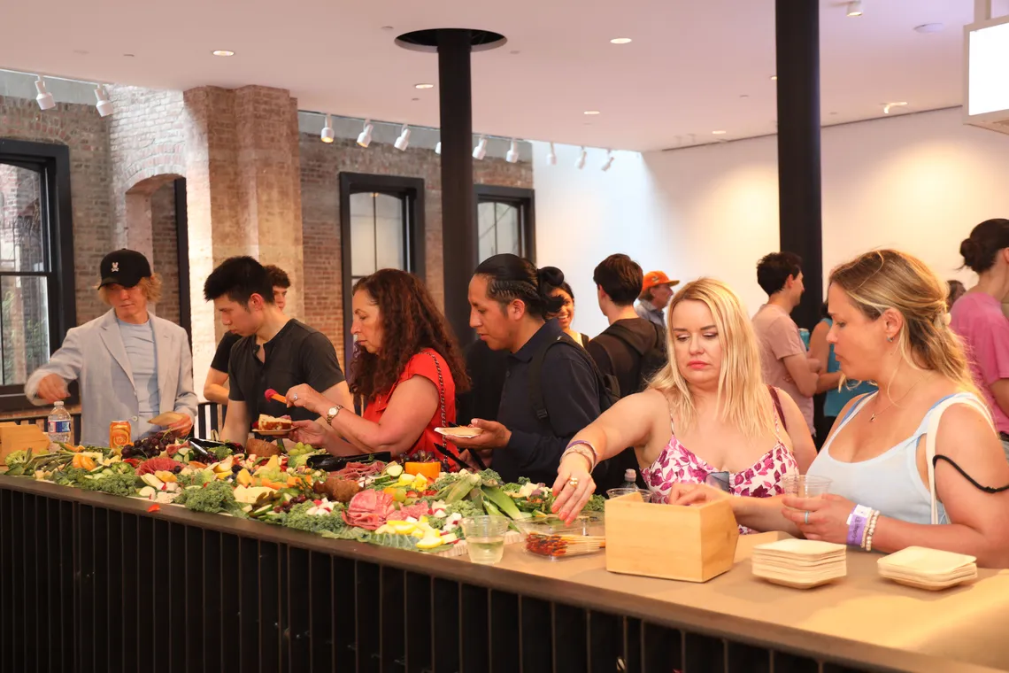 CX and ops leaders networking over wine and cheese before the panel