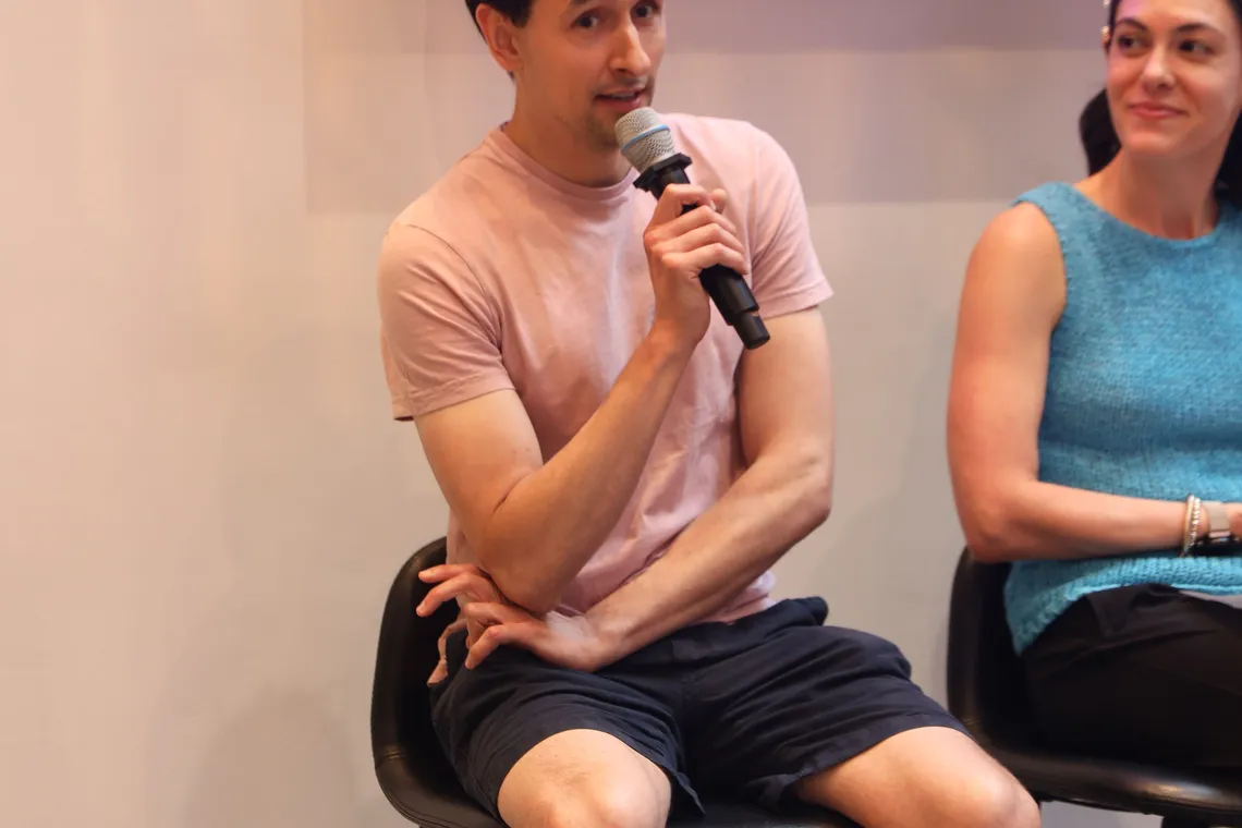 Moderator Anya Kelly leading the panel with a microphone