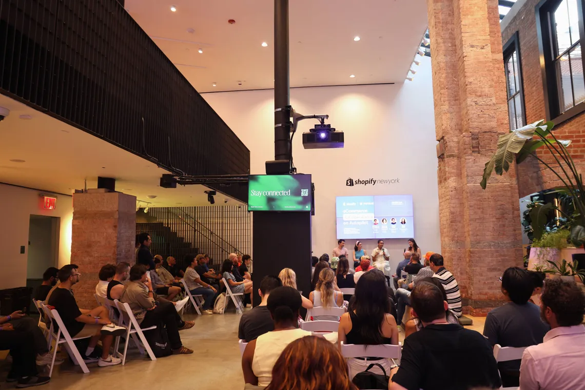 A full room of CX and ops leaders watching the panel at Shopify New York