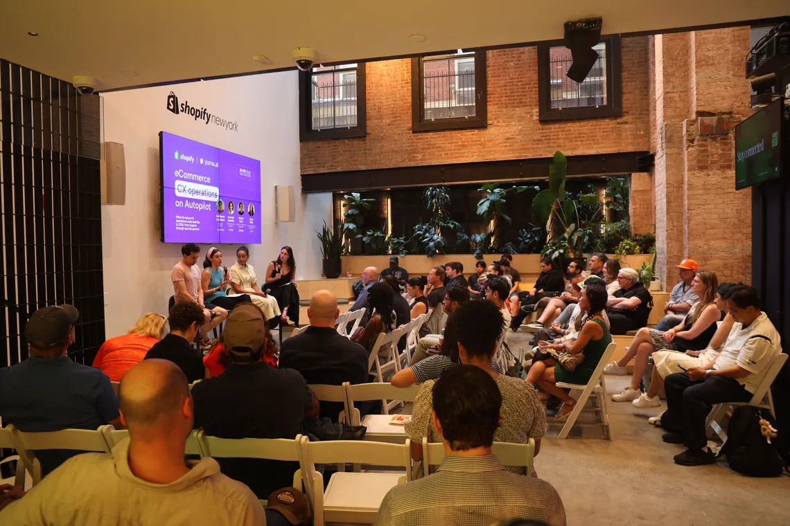 Wide view of the packed venue with the presentation on the video wall